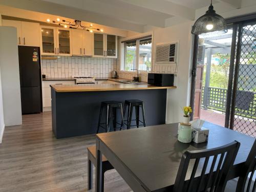 a kitchen with a table and chairs and a counter top at Peaceful 3BR Family Home with free Parking and Garden Oasis in Bayswater