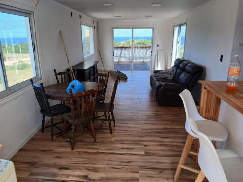 La viuda y el diablo في بونتا ديل ديابلو: غرفة معيشة مع طاولة وكراسي وأريكة