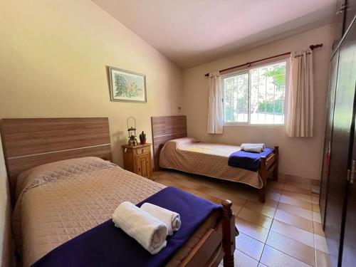 Rocco Housse في لوس هورنيلوس: غرفة نوم بها سريرين ونافذة