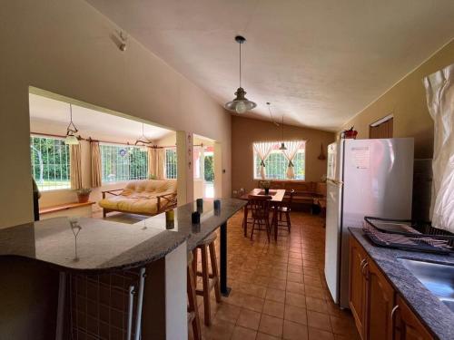 Rocco Housse في لوس هورنيلوس: مطبخ وغرفة معيشة مع ثلاجة وطاولة