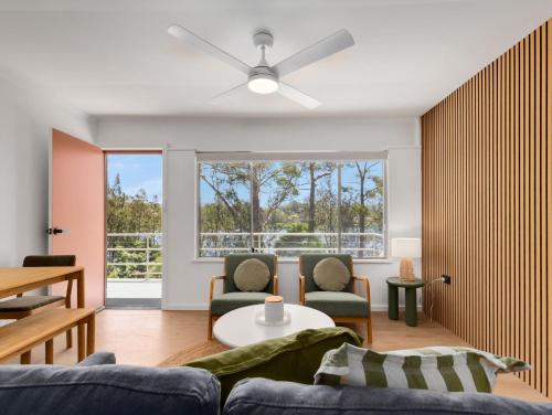 ein Wohnzimmer mit einer Couch und einem Deckenventilator in der Unterkunft Blue Lotus Riverfront Villas Nelligen in Nelligen