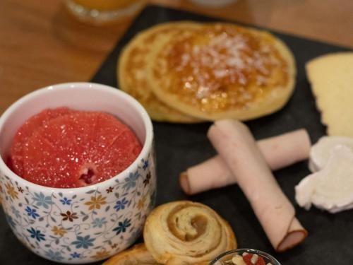 ル・ピュイ・アン・ヴレにあるイビス スタイルズ ル ピュイ アン ブレーのジャムとペストリーのカップが置かれたテーブル