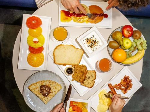 Una mesa con muchos platos de comida encima. en Mercure Rouen Centre Cathédrale, en Rouen