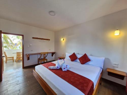 Un dormitorio con una cama con un animal de peluche encima. en La Mirada Del Solitario George, en Puerto Ayora