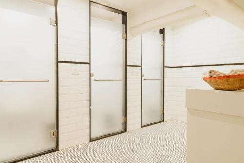a walk in shower with two doors in a bathroom at Abode Bombay in Mumbai
