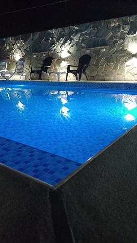 a large blue swimming pool with a chair in it at La Soñada in San Miguel del Monte
