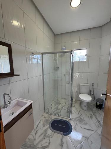 a bathroom with a shower and a toilet and a sink at Flat Prosperidade - Completo No Centro do Capão in Vale do Capao