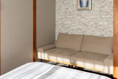 a couch in a room with a brick wall at hotel 翡翠 in Ise