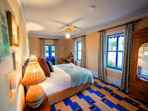 a bedroom with a bed with a lamp and windows at The Sienna Hunter Valley in Luskintyre