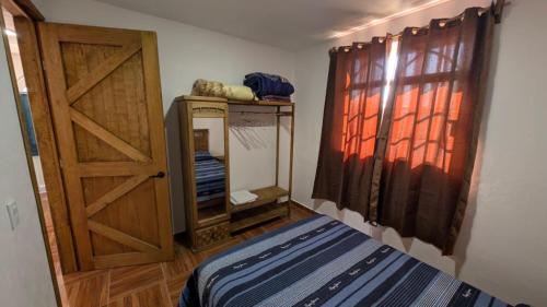 ein Zimmer mit einer Tür und einem Bett und einem Spiegel in der Unterkunft Casa Rancho El Capulín en Grutas de Tolantongo 