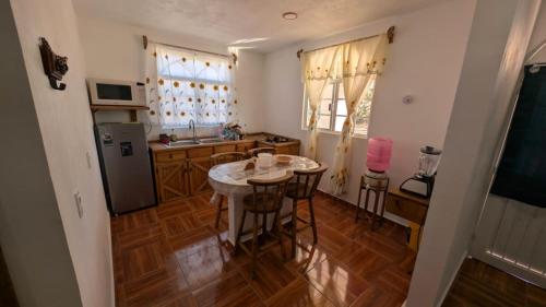 eine Küche mit einem kleinen Tisch und einem Kühlschrank in der Unterkunft Casa Rancho El Capulín en Grutas de Tolantongo 