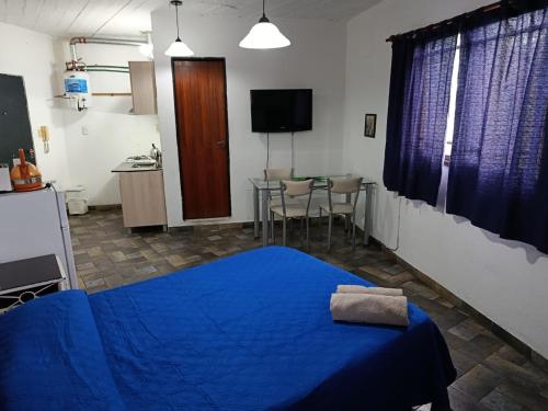 a bedroom with a blue bed and a table at Alojamiento Entero con Excelente Ubicación in Morón