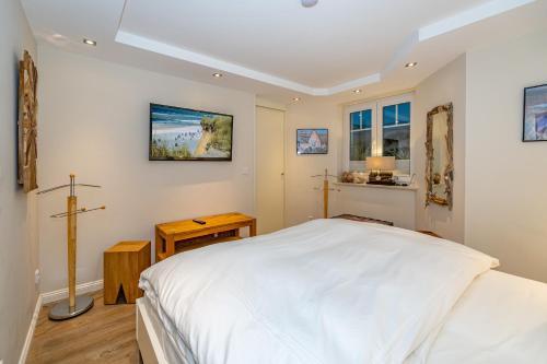 a bedroom with a bed and a cross on the wall at Godewind App 5 in Westerland