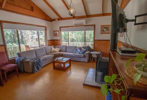 a living room with a couch and a tv at Settlers Chalet in Kalgan