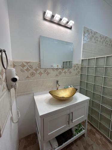 a bathroom with a sink and a mirror at Agape Suites-Room 4- 1st Floor in Soufrière