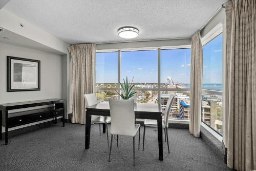 ein Esszimmer mit einem Tisch, einem Schreibtisch und einem Fenster in der Unterkunft Glass Wrapped Around Corner Unit Unbeatable View in Myrtle Beach