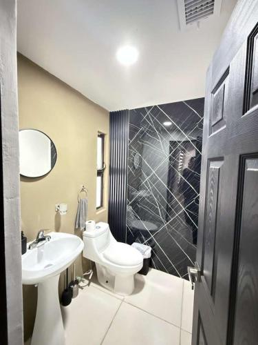 a bathroom with a white toilet and a sink at Casona Álamo in La Coyotera