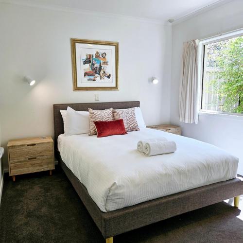 Un dormitorio con una gran cama blanca con dos almohadas rojas. en Garden Retreat on Orr, en Shepparton