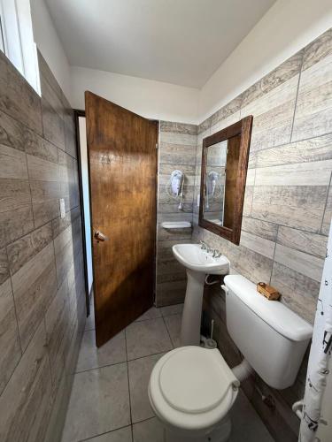 a bathroom with a toilet and a sink at Cabañas La Sonrisa in Puerto San Julián