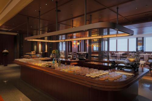 um restaurante com um buffet de comida no balcão em Park Hyatt Tokyo em Tóquio