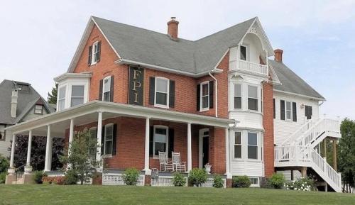 a large red brick house with a sign on it at Heartland suites in Gettysburg