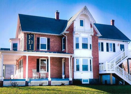 Heartland suites bed and breakfast في غيتسبرغ: منزل من الطوب الأحمر كبير مع وضع علامة عليه