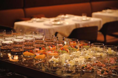 uma mesa repleta de aperitivos e comida em copos em Park Hyatt Tokyo em Tóquio