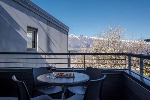 a table and chairs on a balcony with a view at The Alps Apartment in Queenstown