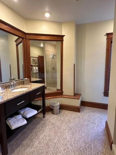 a bathroom with a sink and a large mirror at Heartland suites in Gettysburg