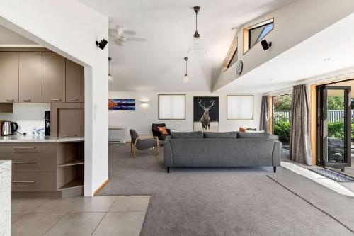 a living room with a couch and a kitchen at Botanical Bliss in Arrowtown