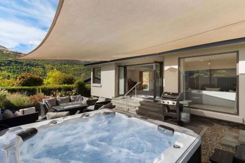 a jacuzzi tub in a patio with a bedroom at Botanical Bliss in Arrowtown