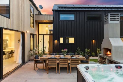 a patio with a table and a hot tub at The Gold Mine in Arrowtown