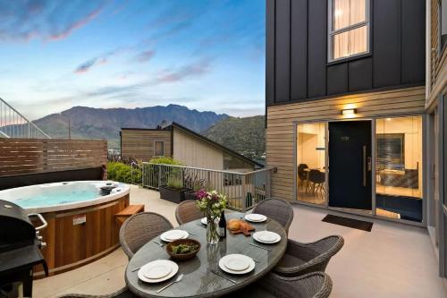a balcony with a table and a hot tub at Bluewater Views in Queenstown