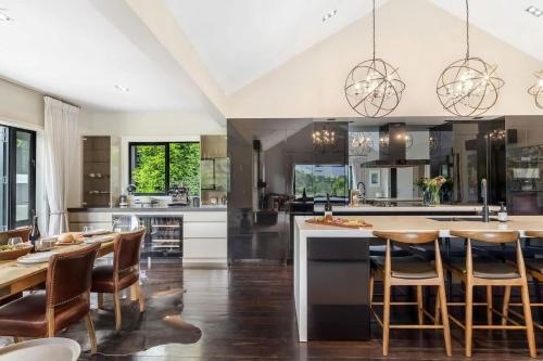 a kitchen with a large island and wooden chairs at The Stowaway in Queenstown