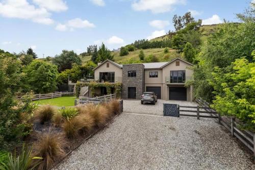 a house with a car parked in the driveway at The Stowaway in Queenstown