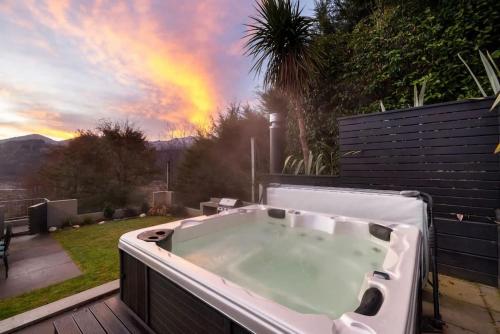 a bath tub on a deck with a rainbow in the background at The Stowaway in Queenstown