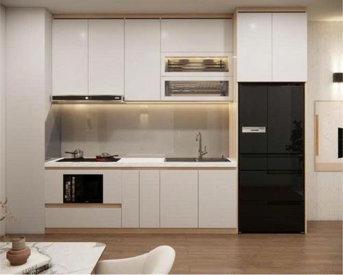 Asahi Luxstay - Benhill Apartment Binh Duong في Thuan An: مطبخ بخزائن بيضاء وثلاجة سوداء