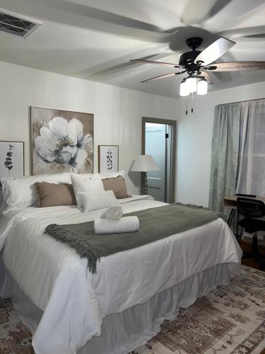 a bedroom with a large white bed with a ceiling fan at Luna Luxury - 2BR near VCU & Richmond Raceway in Richmond