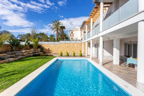 a swimming pool in the backyard of a house at Luxury Vau Beach Villa with Private Heated Pool in Portimão