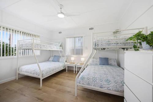 ein Schlafzimmer mit zwei Etagenbetten und einem Schreibtisch in der Unterkunft Nans at Northy - modern river cottage in North Haven