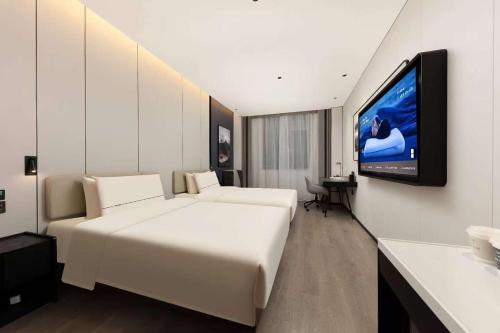 a hotel room with a bed and a flat screen tv at Atour Hotel Shanghai Songjiang G60 Dongjing in Shanghai