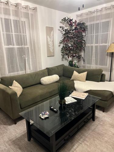 a living room with a green couch and a coffee table at Luna Luxury - 2BR near VCU & Richmond Raceway in Richmond