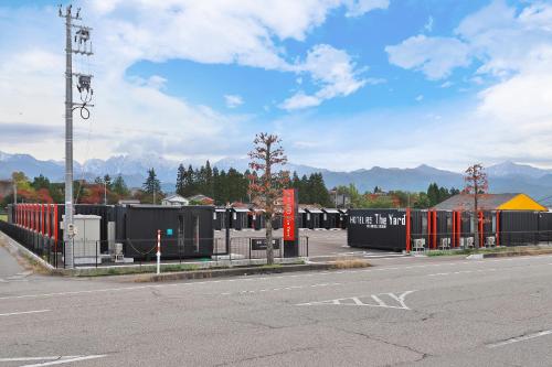 a parking lot with a bunch of black and red containers at HOTEL R9 The Yard Kamiichi in Kamiichi
