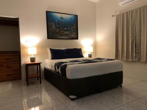 Harbour Place Suites في بلاسينسيا فيليدج: غرفة نوم بسرير كبير مع مصباحين