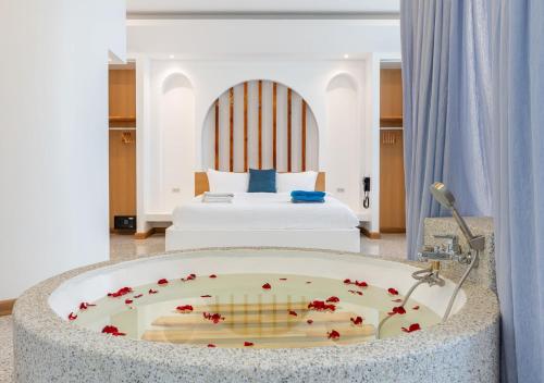 a room with a bath tub with a bed at Downtown Oasis 芭提雅市中心独栋泳池别墅 B 5卧6卫 KTV BBQ 芭提雅海滩步行街500m in Pattaya