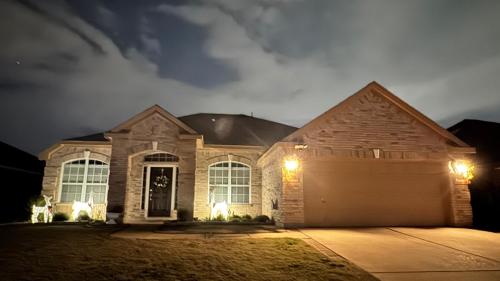 A Beautiful Home in Dallas-Fort Worth في غراند براري: منزل به كراج في الليل مع أضواء