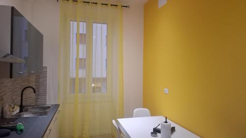 ein Badezimmer mit einem Waschbecken und einem gelben Duschvorhang in der Unterkunft Casa Giulia in Triest