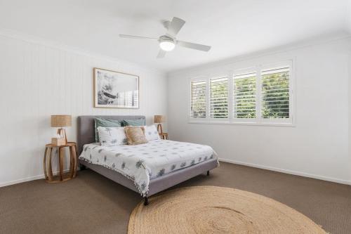 a bedroom with a bed and a window at Spades - at Lighthouse Beach in Port Macquarie