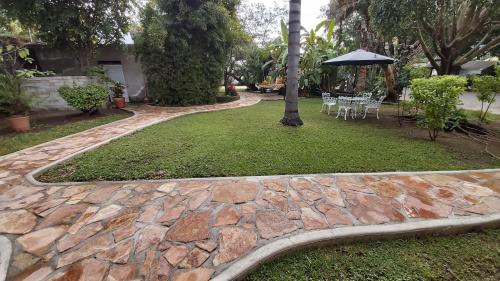 a stone walkway with a table and an umbrella at Posada Sarita in Tepoztlán
