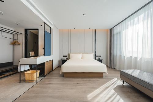 a bedroom with a bed and a desk and a sink at Atour Hotel Jiading Nanxiang in Jiading